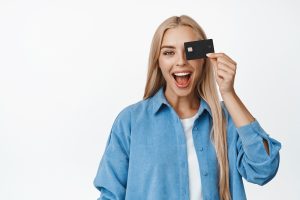 Mujer feliz con su tarjeta Scotiabank IDEAL.