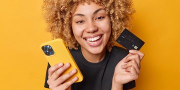 A happy woman using the BMO World Elite Mastercard.