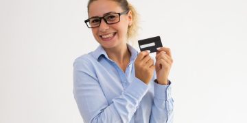 A happy woman holding her Aeroplan Credit Card
