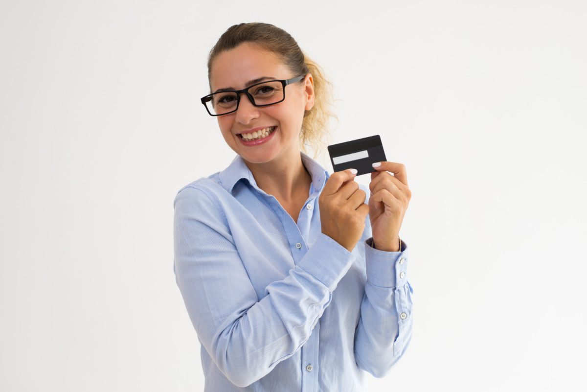 A happy woman holding her Aeroplan Credit Card