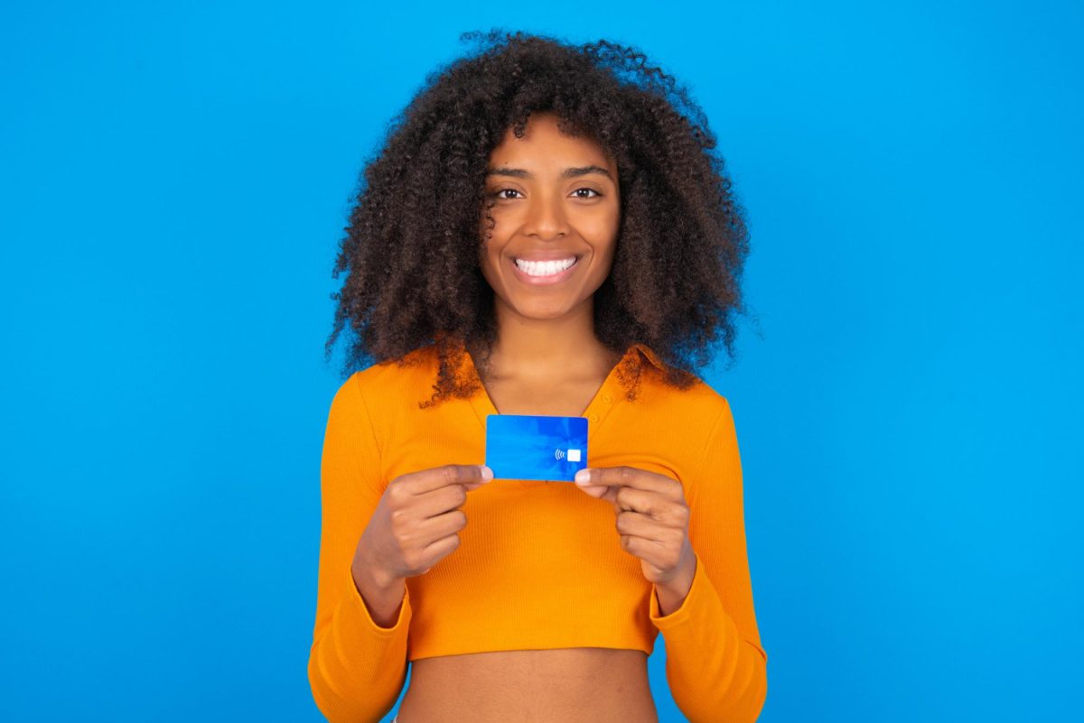 Happy woman holding her Capital One Platinum Credit Card.