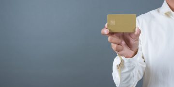 A man holding his Delta SkyMiles Gold American Express.