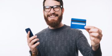 A happy guy holding his Discover it Cash Back credit card.