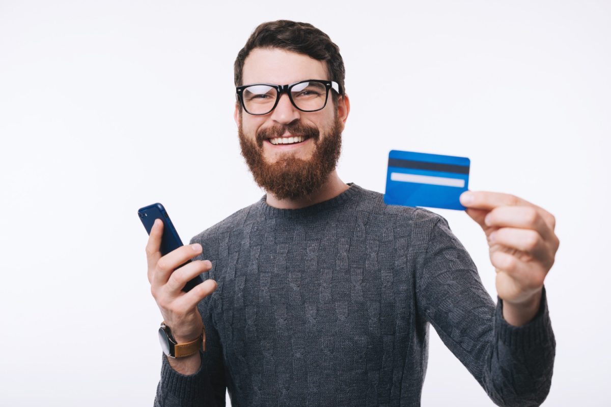 A happy guy holding his Discover it Cash Back credit card.