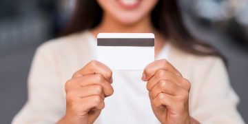 Woman holding her Mission Lane Visa Credit Card.