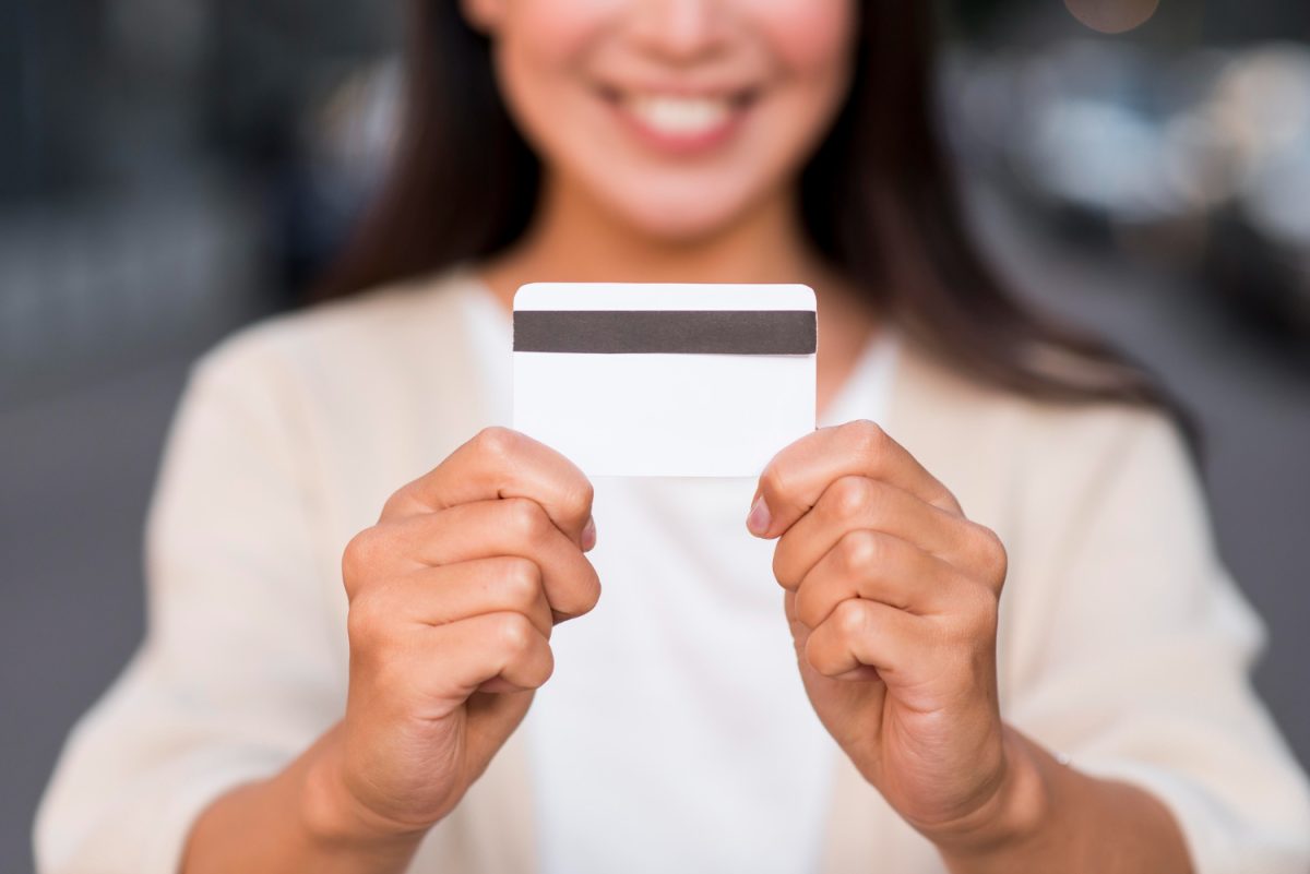 Woman holding her Mission Lane Visa Credit Card.