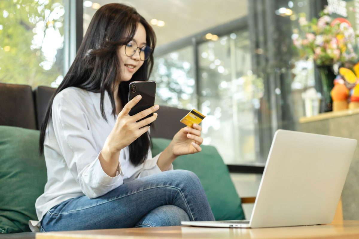 mulher usando bancos digitais no celular e computador.