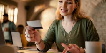 una mujer revisando las Tarifas de tarjeta de crédito.