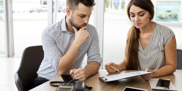 Homem em um banco descobrindo Como reduzir parcela de financiamento.