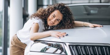 Mulher feliz com carro após o Financiamento de veículos.