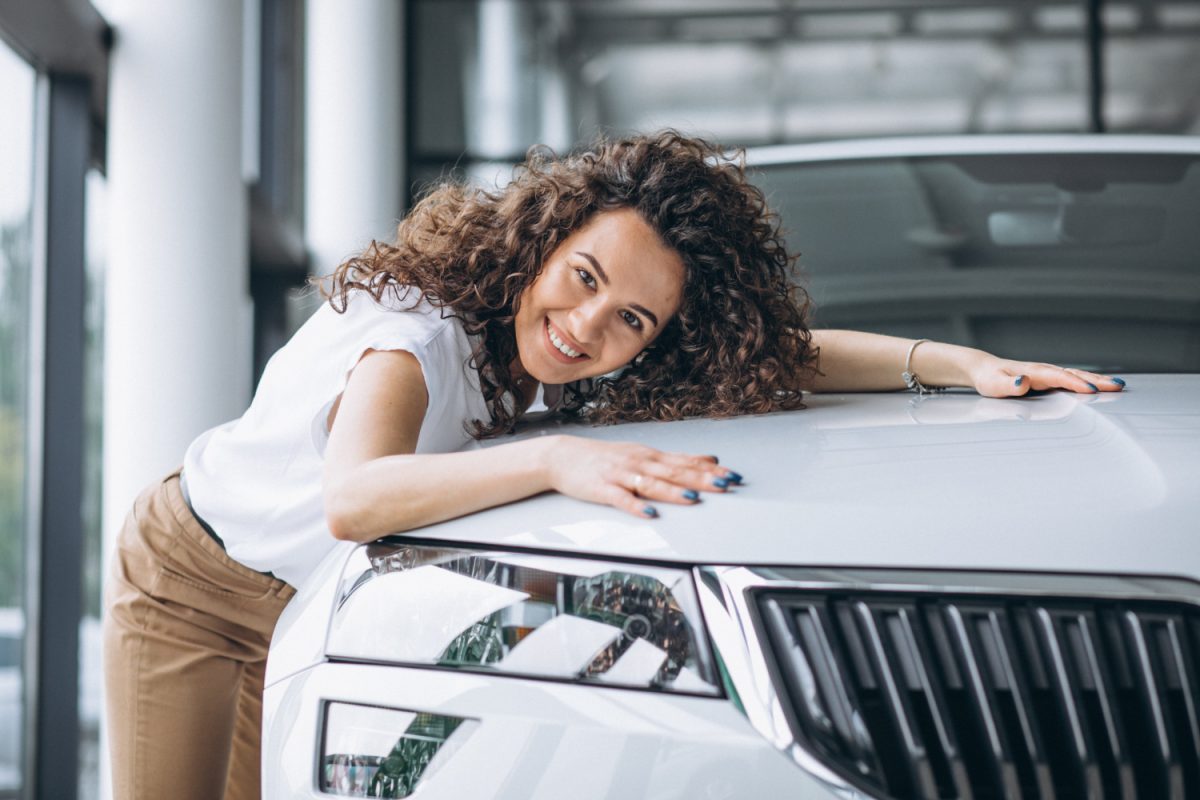 Mulher feliz com carro após o Financiamento de veículos.